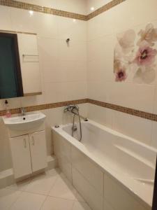 a bathroom with a white tub and a sink at 1к Поділля in Vinnytsya