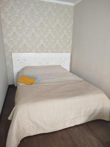 a small bedroom with a bed with a yellow blanket at 1к Поділля in Vinnytsya
