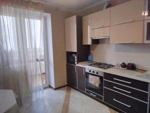 a kitchen with a stove top oven next to a window at 1к Поділля in Vinnytsya