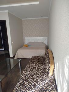 a room with a bed with a leopard print couch at 1к Поділля in Vinnytsya