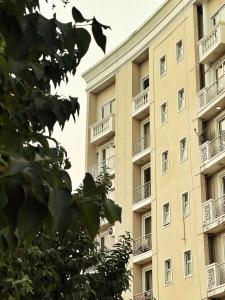 an apartment building with balconies on the side of it at Vrindavan Comfort Stay in Chhatikara