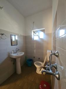 a bathroom with a toilet and a sink at Jaibari Basa in Ukhimath