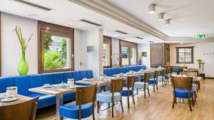 een eetkamer met tafels en blauwe stoelen bij Garner Hotel Stuttgart City Centre by IHG in Stuttgart