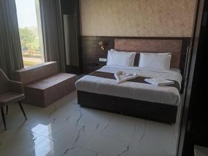 a hotel room with a bed and a chair at Aero Lounge Hotel in Jāmb