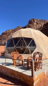 un gruppo di sedie e una tenda nel deserto di Desert Nights Camp a Wadi Rum