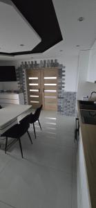 a kitchen with a table and a dining room at Apartament u Krupy z Prywatnym Jacuzzi i tarasem Widokowym in Murzasichle