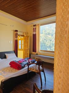 a bedroom with a bed and a window at Jaibari Basa in Ukhimath +14 photos