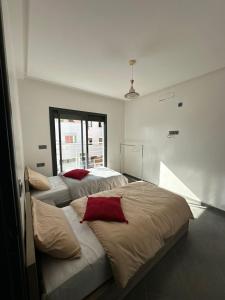 twee bedden in een kamer met een raam bij Maroc Stay in Imsouane