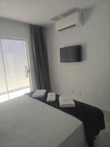 a bedroom with a bed with two towels on it at Oceano Residence in Búzios +5 photos