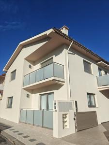 a white apartment building with a balcony at Refugio do Surf Cortegaça in Cortegaça
