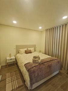 a bedroom with a large bed with vertical blinds at Refugio do Surf Cortegaça in Cortegaça