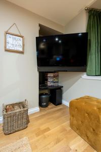 a living room with a large flat screen tv on the wall at Crossroads Cottage in Drumnadrochit