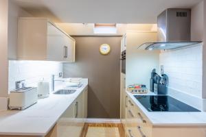 a kitchen with white counter tops and a sink at Crossroads Cottage in Drumnadrochit +31 photos