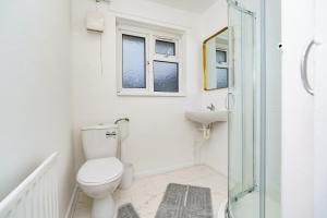 a white bathroom with a toilet and a sink at Open Mind Property- Hot Tub, Sleeps 9 & Free Parking in Portsmouth