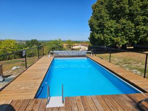 a swimming pool with a wooden deck next to at House on the hill, near Aubeterre-sur-dronne in Saint-Romain