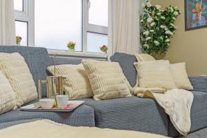 a blue couch with pillows and a tray on it at Open Mind Property- Hot Tub, Sleeps 9 & Free Parking in Portsmouth +24 photos