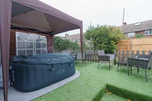 a large blue tub sitting under a tent in a yard at Open Mind Property- Hot Tub, Sleeps 9 & Free Parking in Portsmouth