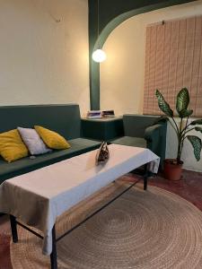 un soggiorno con un divano verde e un tavolo di Olivo hostel a Puerto Escondido