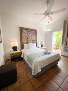ein Schlafzimmer mit Bett und Deckenventilator in der Unterkunft At Wind Chimes Boutique Hotel in San Juan