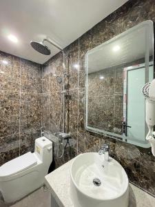 een badkamer met een wastafel, een toilet en een spiegel bij Diamond Hotel in Long Biên +46 foto's