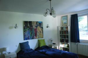 a bedroom with a bed and a painting on the wall at House on the hill, near Aubeterre-sur-dronne in Saint-Romain