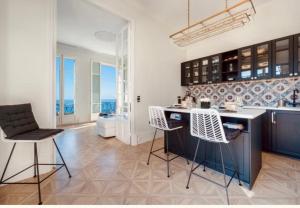 - une cuisine avec une île et des chaises dans la chambre dans l'établissement Cap d'Ail Villa Belle Epoque 5'from Monaco Luxury Penthouse, à Cap d'Ail