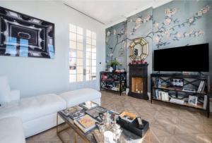 a living room with a white couch and a tv at Luxury Penthouse Villa Belle Epoque Monaco GP in Cap d'Ail +35 photos