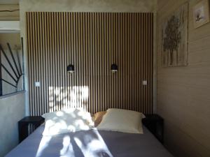a bedroom with a bed with two pillows on it at La Pitchounette Mas Val-Chênaie Gordes in Gordes +15 photos