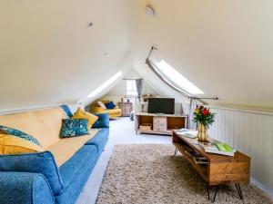 a living room with a blue couch and a table at The Hayloft - Beautiful Barn Stay in Ashford