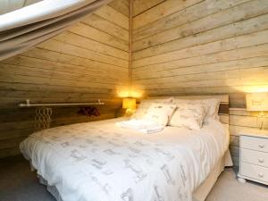 a bedroom with a bed in a wooden room at The Hayloft - Beautiful Barn Stay in Ashford