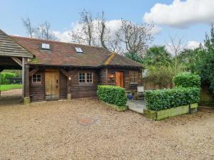a wooden cabin with a yard in front of it at The Hayloft - Beautiful Barn Stay in Ashford