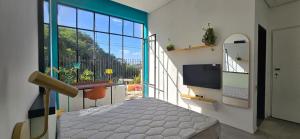 a room with a balcony with a bed and a large window at Castelo dos Tucanos Host in Rio de Janeiro