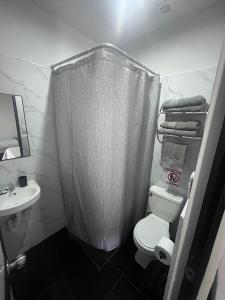 une salle de bain avec un rideau de douche et des toilettes dans l'établissement La Posada de Chango, à La Merced