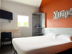 a bedroom with a white bed and an orange wall at ibis budget Carcassonne La Cité in Carcassonne