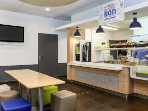 a restaurant with a counter with a table and a bakery at Ibis Budget Lille Gares Vieux-Lille in Lille