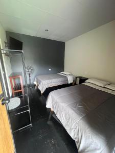 une chambre d'hôtel avec deux lits et un miroir dans l'établissement La Posada de Chango, à La Merced