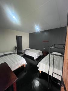 une chambre avec deux lits et une table dans l'établissement La Posada de Chango, à La Merced 10 autres photos