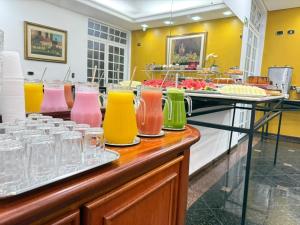 a buffet with many different colored vases on a counter at Hotel Golden Star in Curitiba
