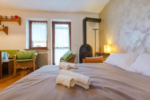 une chambre avec un grand lit avec deux serviettes dessus dans l'établissement Sasso Bianco Home - Mountain View & Private Parking, à Sottoguda