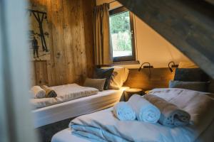 une chambre avec deux lits et une fenêtre dans l'établissement Alpenchalet Deluxe Afritz, à Feld am See