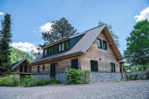 une maison en bois avec un toit à la mansarde dans l'établissement Alpenchalet Deluxe Afritz, à Feld am See