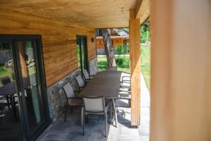 - un coin repas avec une table et des chaises sur la terrasse dans l'établissement Alpenchalet Deluxe Afritz, à Feld am See