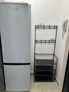 een witte koelkast in een kamer met een trap bij Studio Relax2 in Bacău