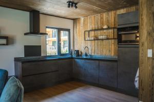 une cuisine avec un évier et une cuisinière four supérieur dans l'établissement Alpenchalet Deluxe Afritz, à Feld am See 20 autres photos