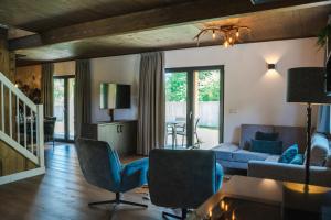 un salon avec un canapé bleu et des chaises dans l'établissement Alpenchalet Deluxe Afritz, à Feld am See