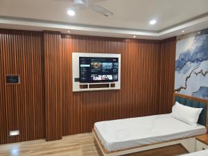 een kamer met een bed en een tv aan de muur bij Falah Homestay in Bokākhāt