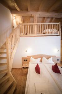 ein großes Bett in einem Zimmer mit einer Treppe in der Unterkunft Maso Fior di Bosco - Val di Rabbi - Esercizio Rurale in Rabbi
