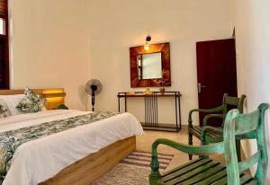 a bedroom with a bed and a mirror and a chair at Dark Green Resort - Airport Transit Villa in Negombo