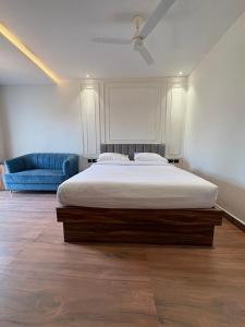 a bedroom with a bed and a blue couch at Lume Stayz in Siolim