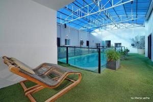 a wicker chair sitting next to a swimming pool at Don Leon Boutique in Even Menahem